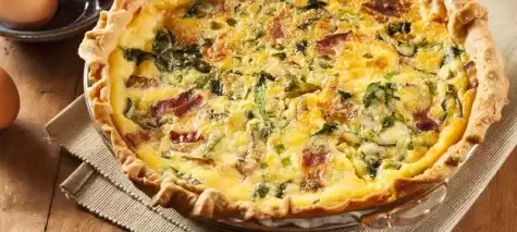 Front shot of Keto Quiche on top of brown cloth with eggs on the side