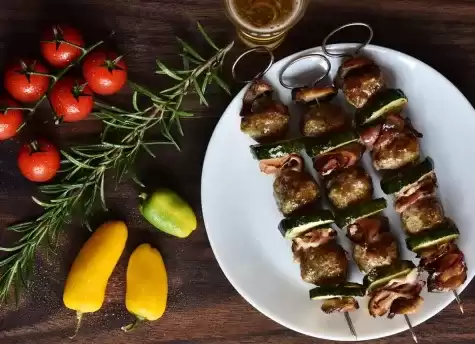 Chicken skewers on a plate with fresh vegetables.