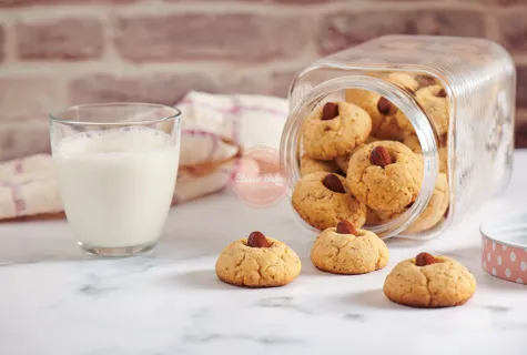 Almond Flour Cookies spilling out of a jar next to a glass of milk