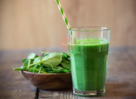 Spinach Smoothie in a glass cup with a straw