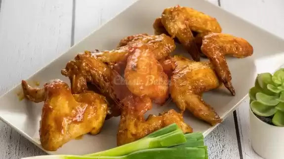 Air fryer buffalo chicken wings on a platter with scallions