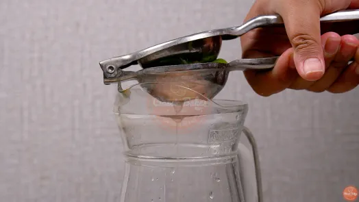 2 limes being squeezed in a lime press