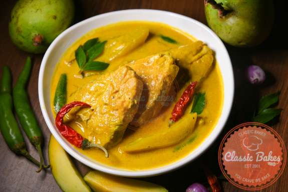 Close Up King Fish Curry with fresh fruits and vegetables on the side