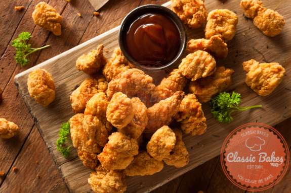 Aerial view of KFC styled Popcorn Chicken in wooden board