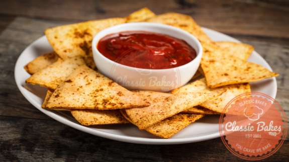 Homemade Tortilla Chips in a plate with salsa dip 
