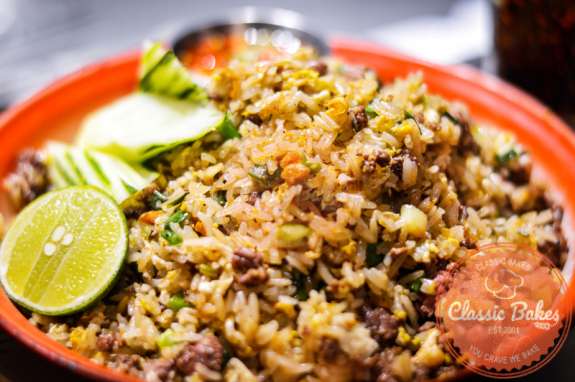 Close up shot of Beef Fried Rice with slices of lime on the side