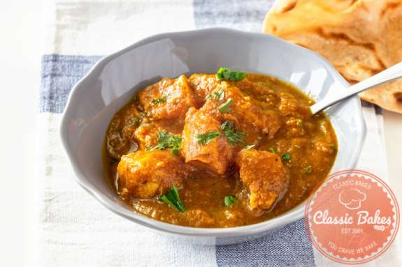 Front shot of Butter chicken in a bowl with a spoon