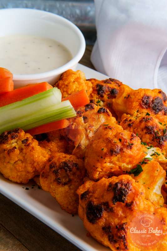 Close up shot of Cauliflower Bites with a dip on the side