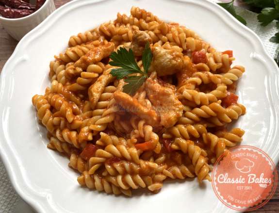 Front shot of Fusilli Pasta with Chicken in a plate with garnish
