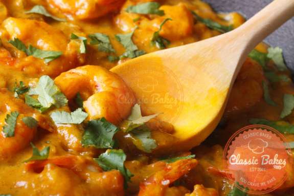 Close up shot of Curry Shrimp with wooden spoon