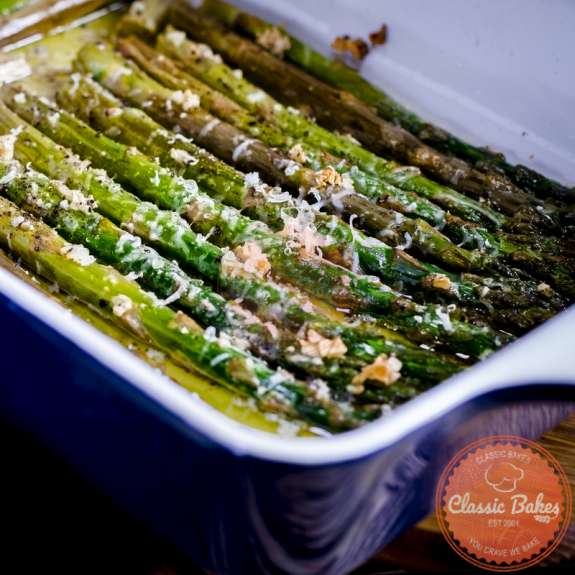Close up shot of Garlic Parmesan Asparagus in a blue baking dish