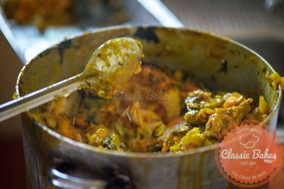 Oil Down Recipe - Grenada's National Dish in a deep pot with spatula