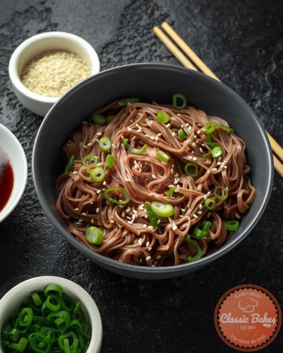 Front shot of Sesame Soba Noodles in a bowl with garnish and chopsticks on the side