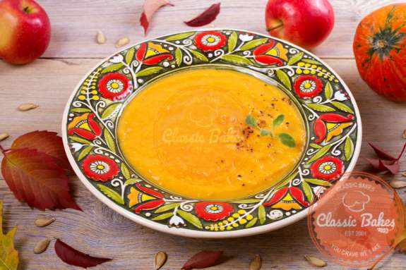 Front shot of Roasted Butternut Squash Apple Soup in a soup plate with spoon