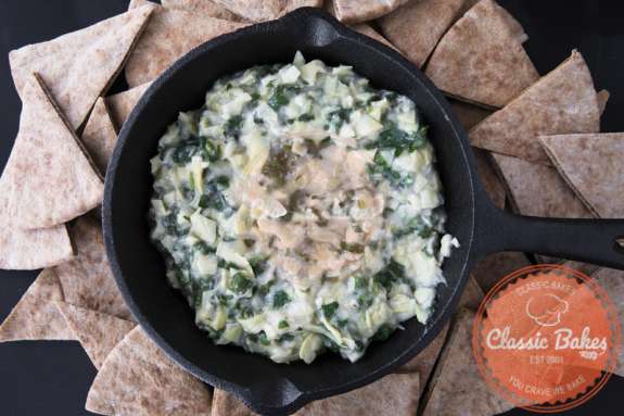 Aerial shot of Vegan Spinach Artichoke Dip with chips on the sides