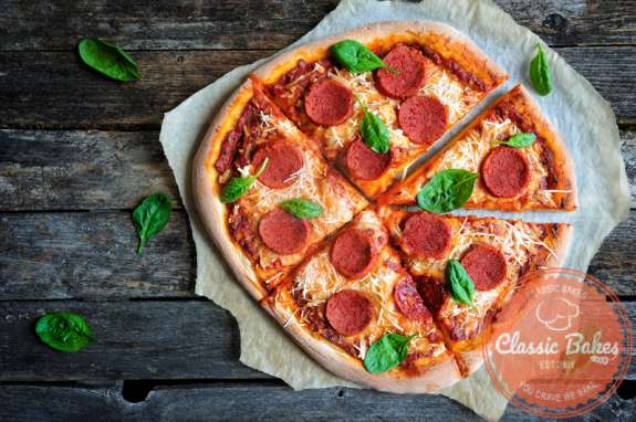 Aerial shot of Vegan pepperoni pizza on wooden background