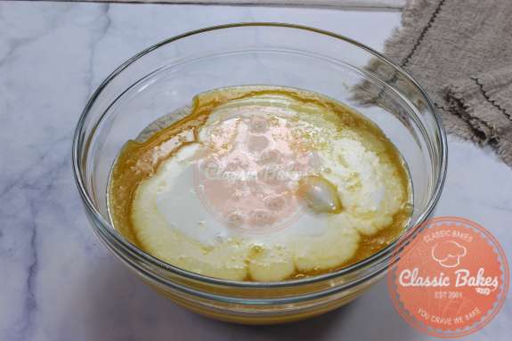 Overview of a glass bowl containing egg mixture and buttermilk 