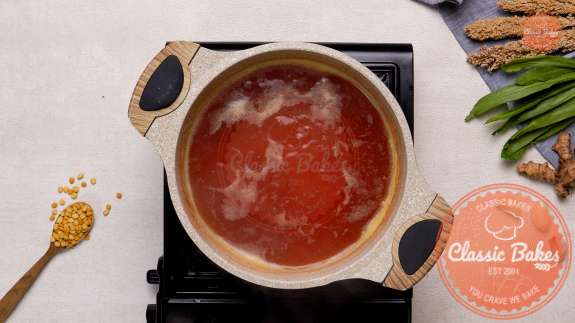 Overview of a pot on the stovetop filled with water cooking dhal 