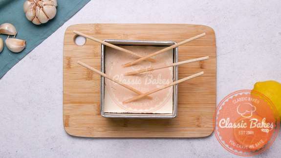 Arial view of a pan of vegan swiss cheese with chopsticks inside it
