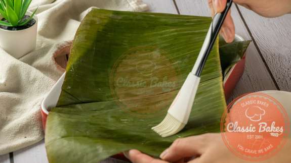 Banana leaves being brushed with oil 