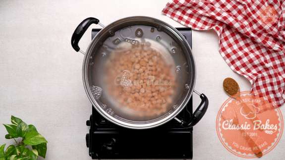 Boba pearls being added to a pot of boiling water 