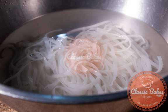 Bowl with rice noodles being soaked in water 