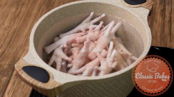 Chicken feet being boiled in a pot of water 