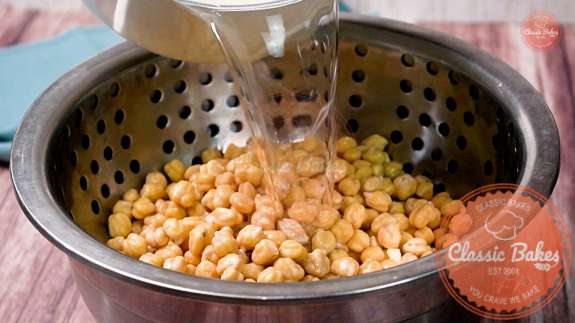 Chickpeas being rinsed in a colander 
