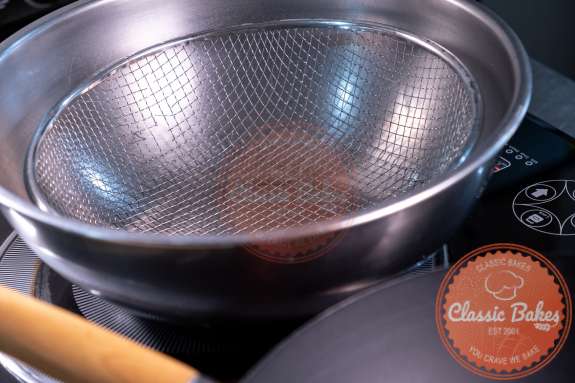 A colander set up as a drying station with a bowl underneath 