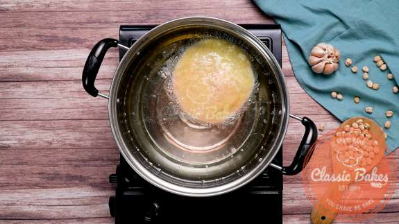 Dough frying in a pot of oil 