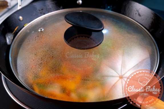 Escovitch simmering in a covered wok 
