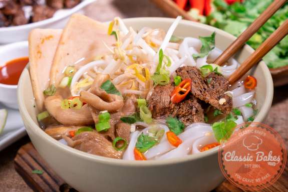 Finished bowl of vegan Vietnamese pho with chopsticks inside 