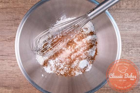 Flour and spices being whisked in a bowl 