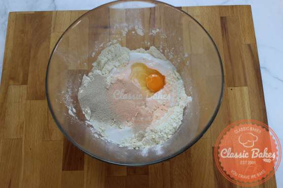 Glass bowl containing egg milk flour and yeast 