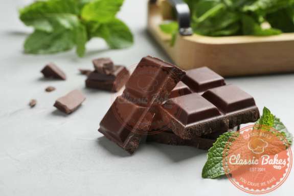 dark chocolate squares with fresh mint leaves on a countertop 