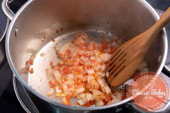 Onions and seasonings being sauteed in a pot 