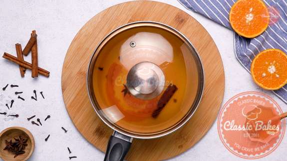 Orange peel tea steaming in a covered pot 