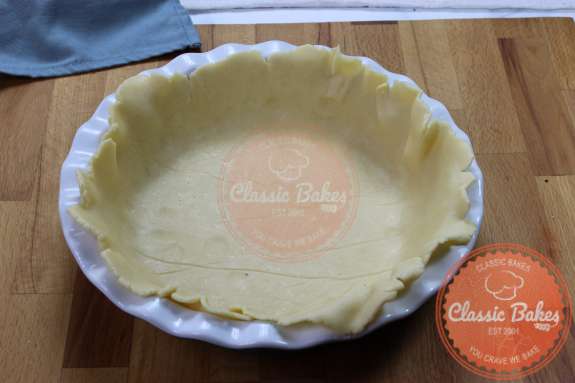 Overview of a pie pan with the bottom layer of pie crust inside 