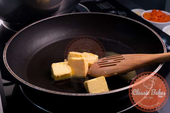 A pan with a wooden spoon and melting cubes of butter 
