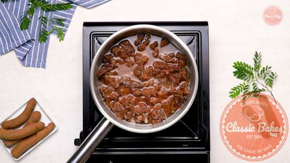 A pot with water and tamarind pulp boiling on a stovetop 