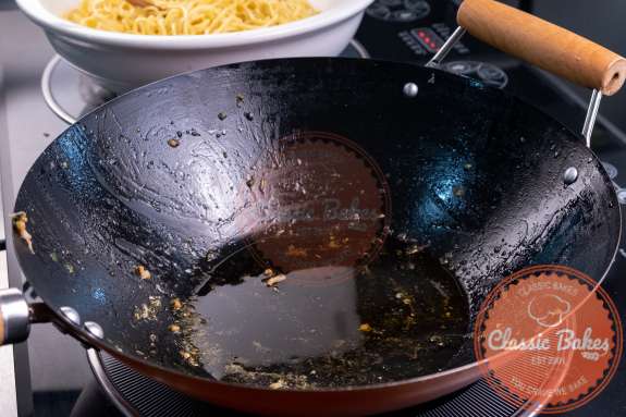 Sesame and peanut oil heating up in a wok 