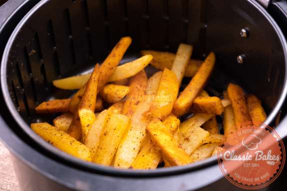 Sideview of fries in an air fryer basket 