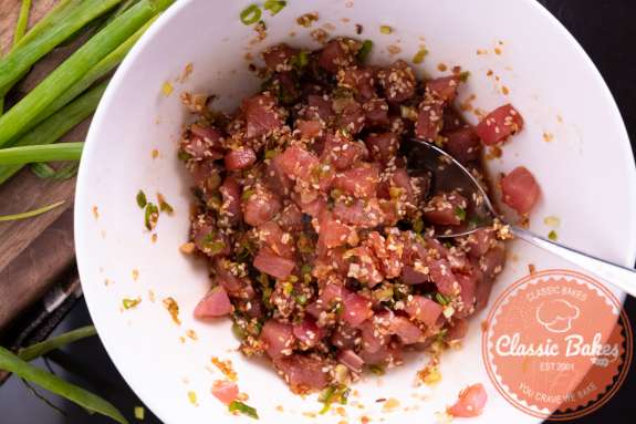 Tuna Tartare being mixed in a bowl with a spoon 