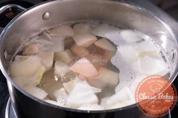 Vegetables being boiled in a large pot 