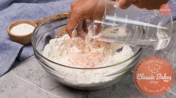 Water being added to dry ingredients in a bowl 