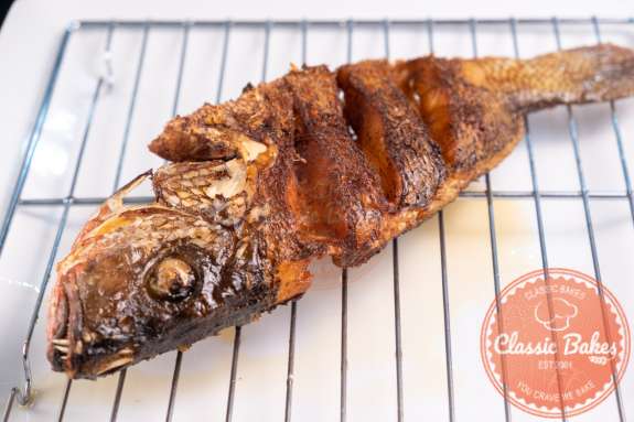 Whole fried fish on top of a cooling rack 
