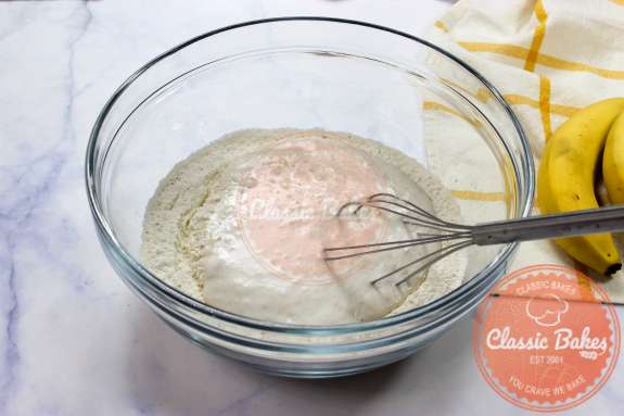 Pancake batter being mixed in a glass bowl 