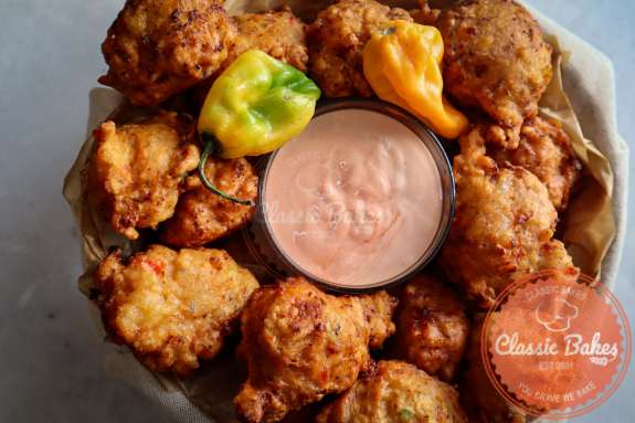 Overview of Bahamian conch fritters with dipping sauce in the middle