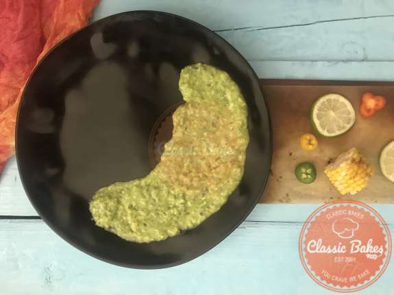 Areal view of half a plate coated with avocado sauce 