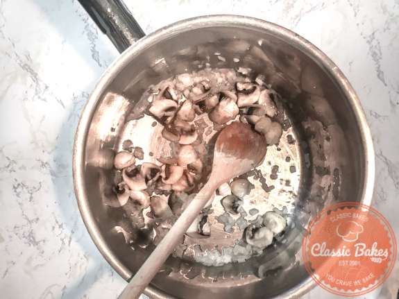 Arial view of mushrooms and shallots being sauteed in a pot